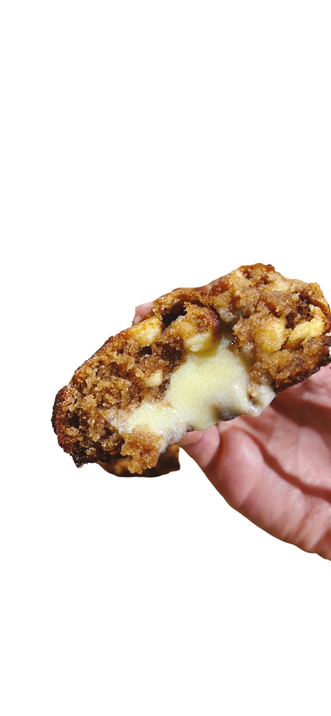 Galleta keto de cinnamon roll partida, con la crema de canela visible en el centro