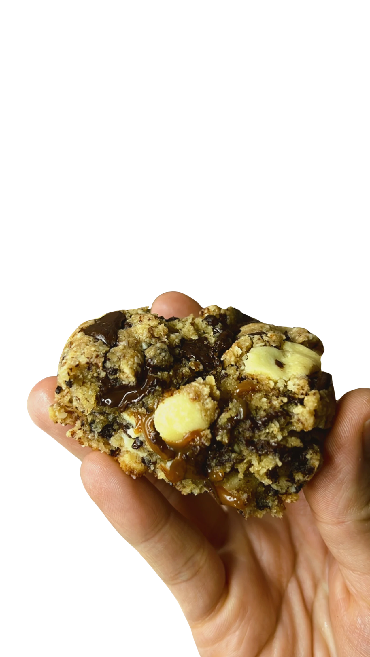 Galleta keto de café y nuez del Brasil sostenida en la mano, con caramelo de café y chips de chocolate en el interior