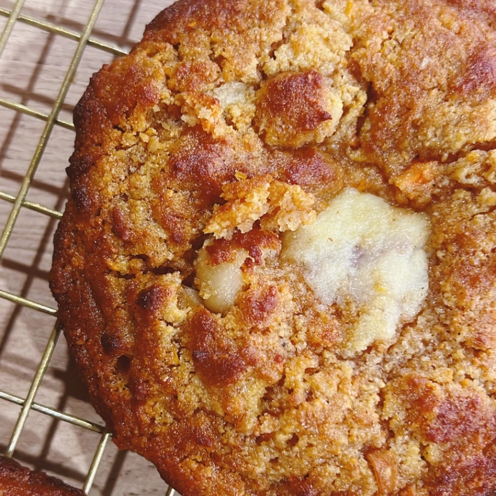 Galleta saludable estilo torta de zanahoria sobre rejilla, gruesa y dorada con relleno de crema de queso